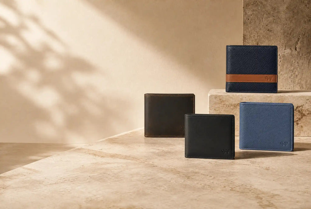 Four full-grain leather wallets on a stone ledge