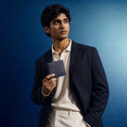 Wildebeast The Frontier navy blue leather wallet held by a man in a blazer against a blue background