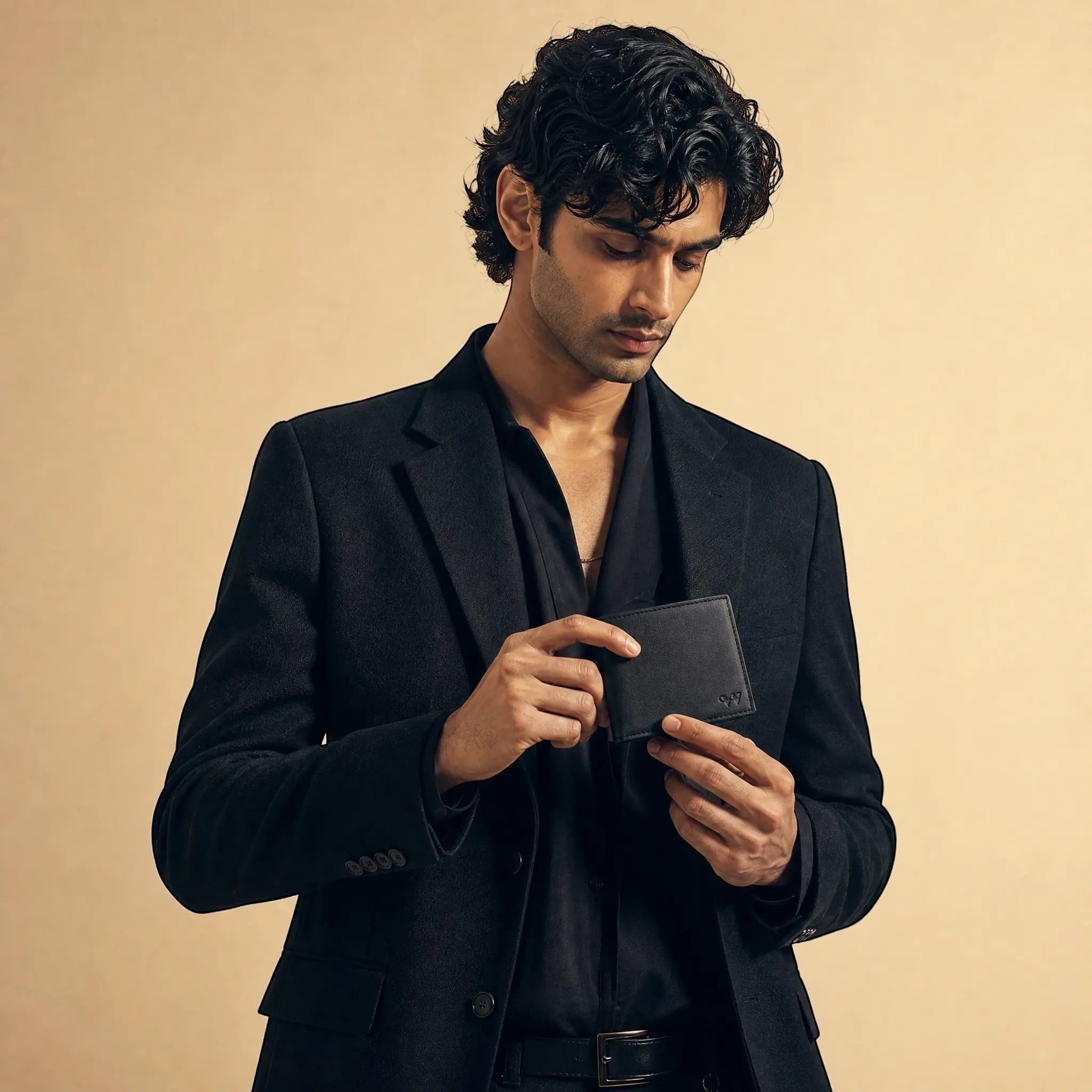 Wildebeast The Drift slim black Nappa leather bifold wallet held by a man in a black blazer
